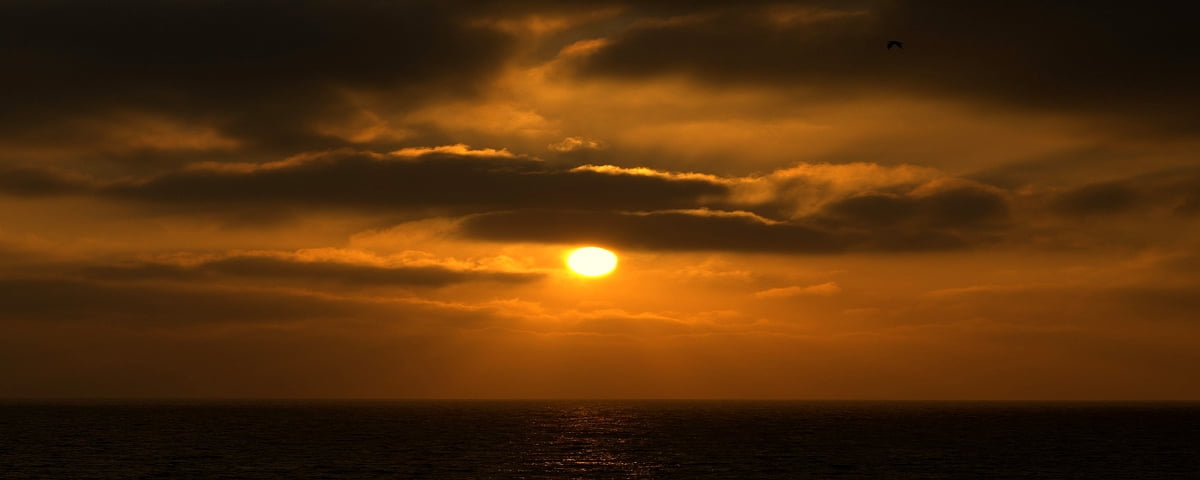 HD images de fond - coucher de soleil sur l'océan par temps nuageux 2560x1024