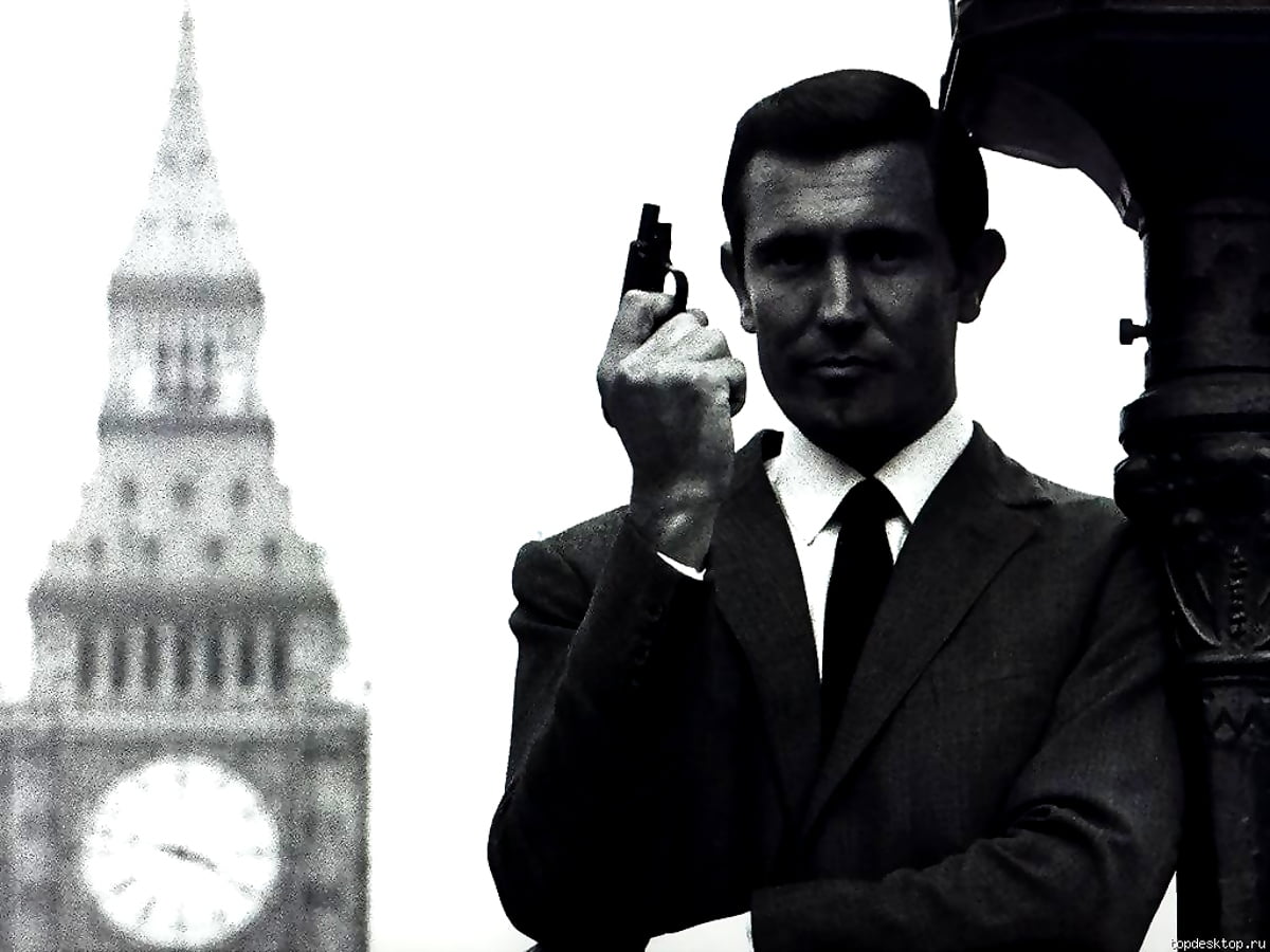 George Lazenby debout devant le bâtiment (scène du film "James Bond") : gratuit photo pour fond d'écran