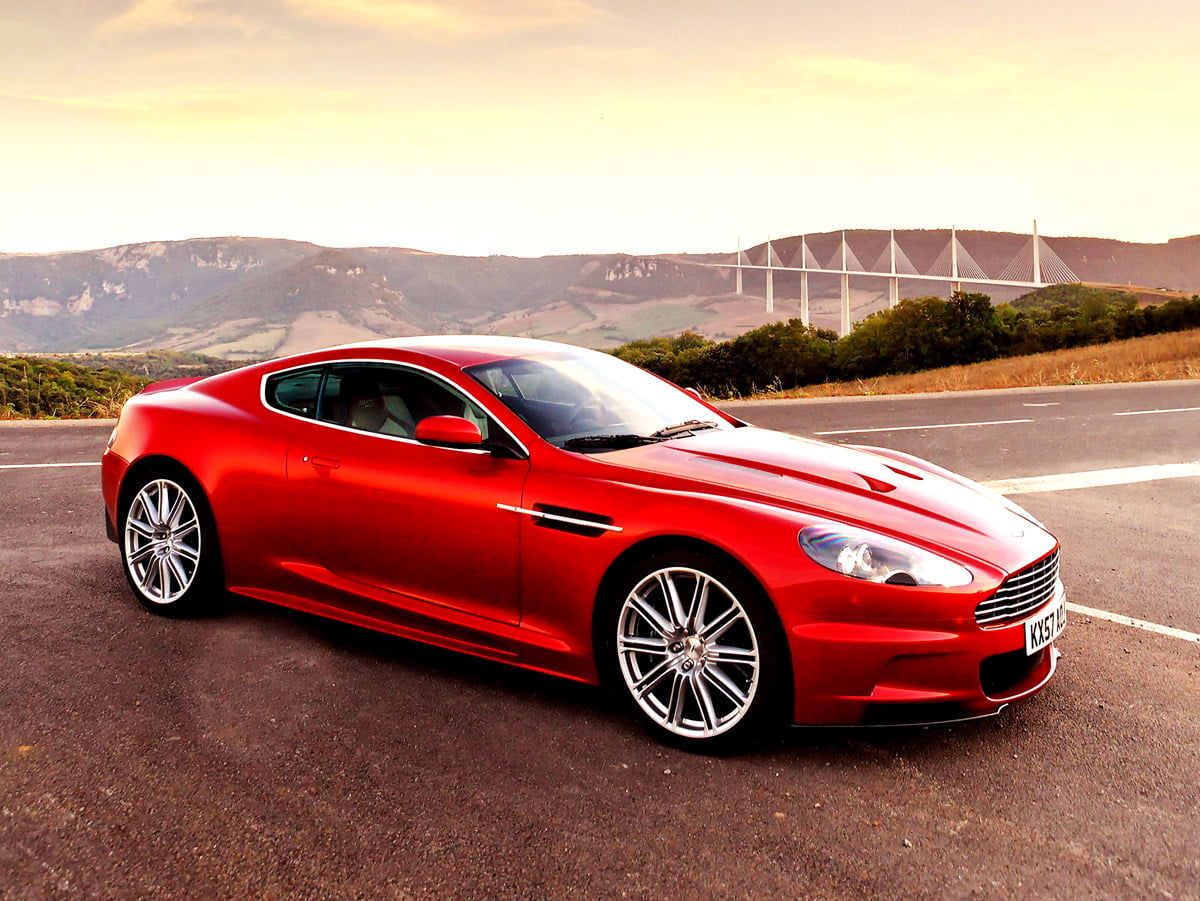 Red Aston Martin parked in parking lot — background image (1917x1440)